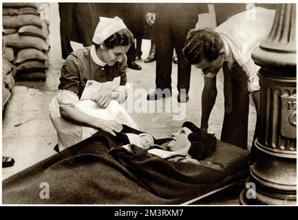 A nurse giving a few words of encouragement to a new mother and her baby as she lies on a stretcher, waiting to be evacuated by ambulance from Westminster hospital. In early September 1939, just after the outbreak of war, many inner city hospitals were evacuated as a precaution against air raids.  September 1939 Stock Photo