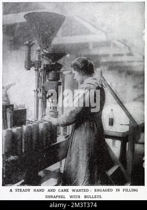 Society volunteers helping soldiers to win World War One in Vickers munitions factory, Erith in Kent. Photograph showing woman working an eight hour shift, operating a machine that filled shrapnel and bullets.       Date: 1915 Stock Photo