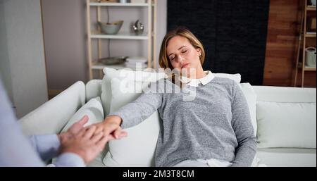 Hypnotherapy Psychotherapy Treatment. Woman Hypnotized By Hypnotist Stock Photo