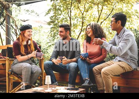 Happy friends having break together, students lifestyle, multiracial group of young people drinking coffee, talking and having fun Stock Photo