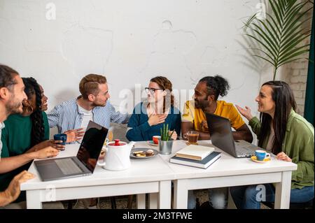 Friends group drinking cappuccino at coffee bar, universitary students talking and having fun together at fancy cafeteria, friendship concept with hap Stock Photo