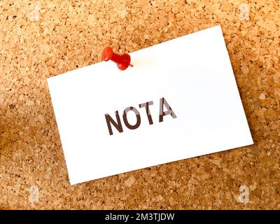 Blank note white on a cork board with text note in spanish Stock Photo