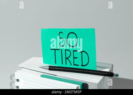 Hand writing sign So Tired. Word Written on drained of strength and energy Fatigued to the point of exhaustion Stock Photo