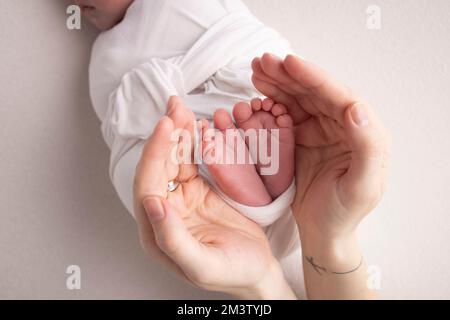 The palms of the father, the mother are holding the foot of the newborn baby  Stock Photo