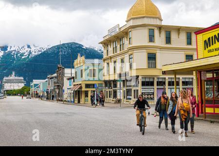 Tourists stroll State Street; cruise ship in harbor; Skagway; Alaska; USA Stock Photo