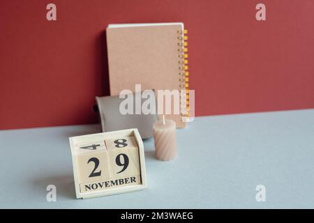 Wood calender and note, pouch, candle on desk. New year planning, schedule organizing, home office concept. red and gray background Stock Photo