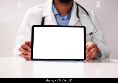 Young Happy African Doctor Working On Computer At Desk Stock Photo