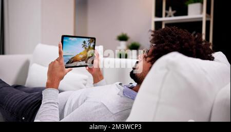 African American Man Watching Tv Movie On Tablet Stock Photo