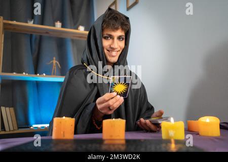 Fortuneteller reading tarot cards having online session using laptop, webcam view, POV Stock Photo
