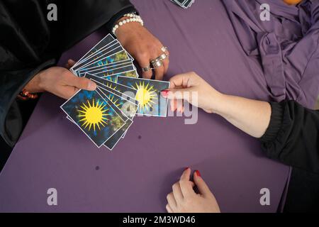 Tarot cards, fortune teller hands on a table background, top view. Future reading concept. Divination. Stock Photo