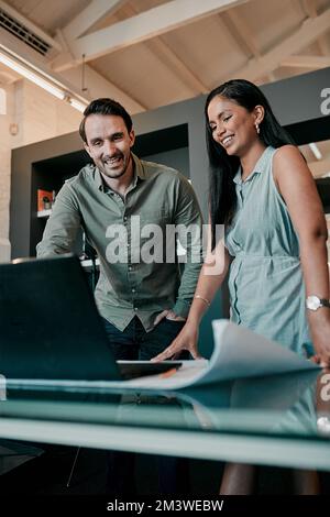 They do well when they collaborate. two young architects working together in a modern office. Stock Photo