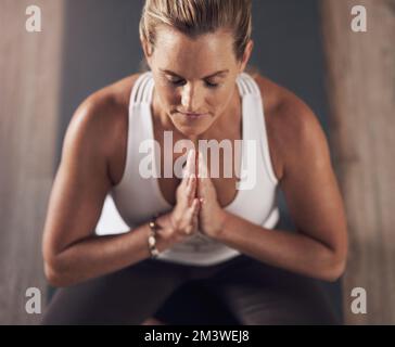 Inner peace is what Im in seek of. an attractive young woman meditating and practicing yoga indoors. Stock Photo