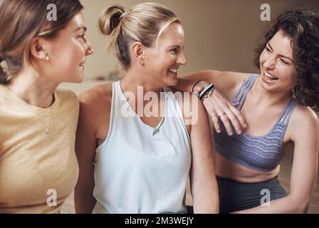 Friends who do yoga together stick together. a young group of women sitting together and bonding during an indoor yoga session. Stock Photo