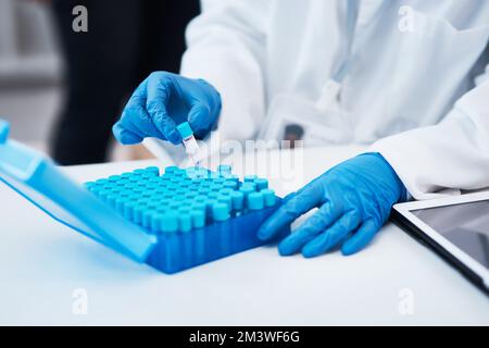 So many samples to work with. Closeup shot of an unrecognisable scientist working with samples in a lab. Stock Photo