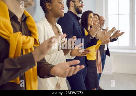 Happy multiracial business people applaud with pleasure after listening to conference or seminar. Stock Photo