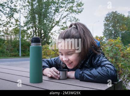 Thermos with a hot drink on mountain waterfall Stock Photo by YouraPechkin