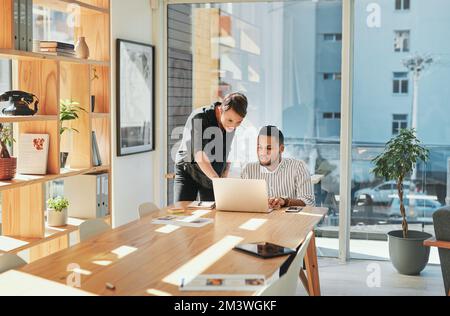 What about this over here. two young business colleagues having a discussion and working on a laptop together in the office. Stock Photo