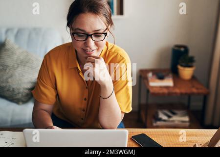 Never lose sight of your future success. a young woman using a laptop while working from home. Stock Photo