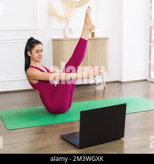 Woman doing Paripurna Navasana exercise, practicing yoga, feet close up  Stock Photo
