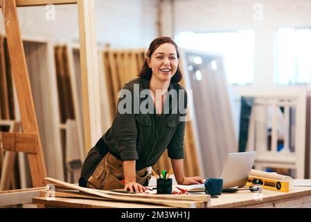 Give your home a new look with our woodwork. a young female carpenter smiling at the camera. Stock Photo