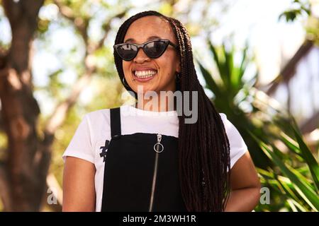Im headed to wherever the fun is at. an attractive young woman wearing sunglasses relaxing in a park outdoors. Stock Photo