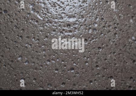 Concrete surface with voids and bubbles, covered with varnish. Building background Stock Photo