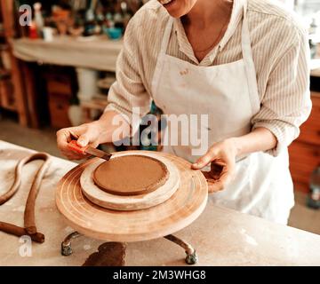 Artists put the thought, time and care into making masterpieces. an unrecognizable artisan working in a pottery workshop. Stock Photo