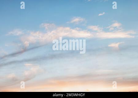 Background of evening sky, light stretched clouds in the sun. Sky with a gradient of color from warm to cold Stock Photo