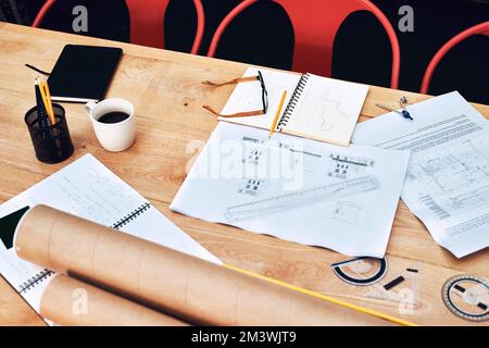 The desk of creativeness. Still life shot of a pair of spectacles placed on top an architects blueprints in a modern office. Stock Photo