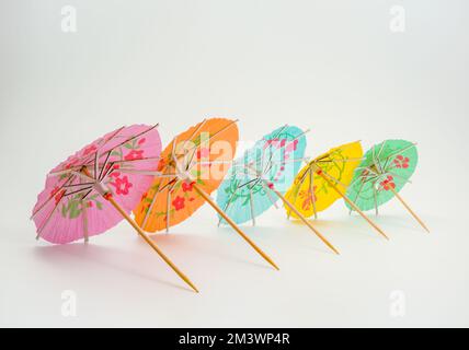 perspective view of a row of cocktail parasol umbrellas isolated against a white background Stock Photo