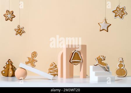 Christmas composition with gingerbread cookies in trendy minimalistic style. Different geometrical shapes, podiums and christmas cookies on neutral cream background. Copy space Stock Photo