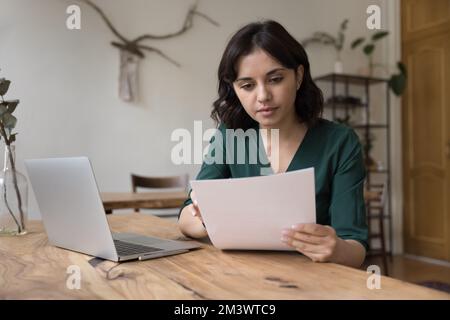 Serious freelance business woman working on report at home Stock Photo