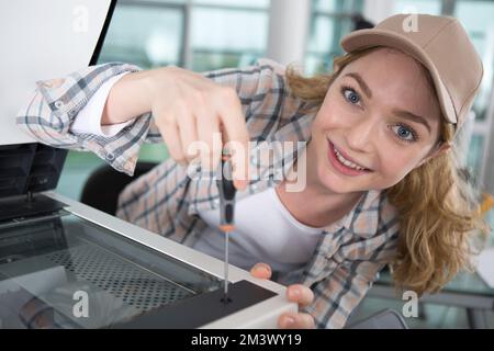 happy woman is fixing a printer Stock Photo