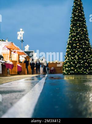 Christmas Market. Low angle view of a few Vendors Present with a big christmas tree and decoration Stock Photo