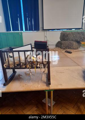 The aftermath of a primary school nativity play in an English school with props unceremoniously dumped in the crib on top of the baby Jesus Stock Photo