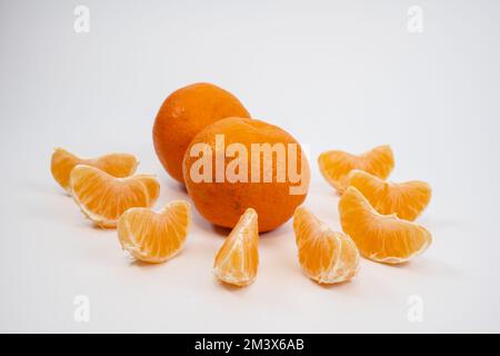 couple of satsumas tangerines with orange segments isolated on a clean white background Stock Photo