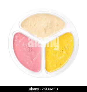 Hummus dip varieties in a clear plastic container. Natural hummus with cumin, yellow curry and red beetroot. Middle Eastern dip and spread. Stock Photo