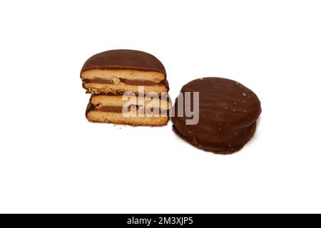 Baked biscuits covered with brown chocolate and stuffed with chocolate cream isolated on white background, selective focus of a chocolate sweet biscui Stock Photo