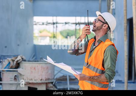 Engineer builder foreman work radio call in construction site. Architect worker project designer leader concept. Stock Photo