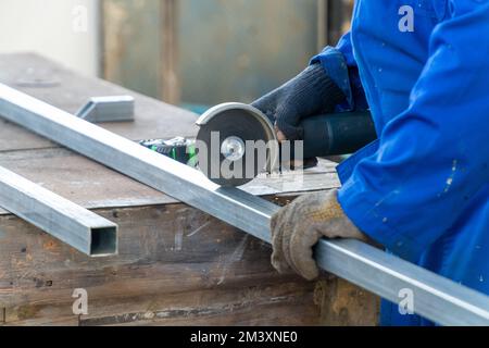 Factory worker using a grinder to cut iron Stock Photo