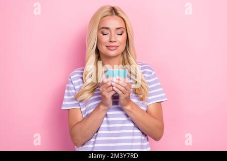 Photo of cute positive good mood relaxed lady hold mug aroma latte smell morning fresh coffee beans enjoy isolated on pink color background Stock Photo