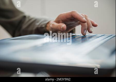 Low angle closeup view of female hand typing and using black laptop computer keyboard. Stock Photo