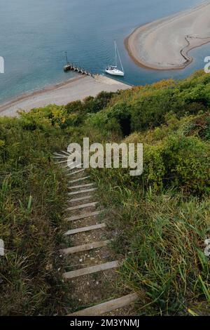 A vertical shot of a pathway on a grassy hilltop near the River Axe Estuary near Seaton, East Devon, UK Stock Photo