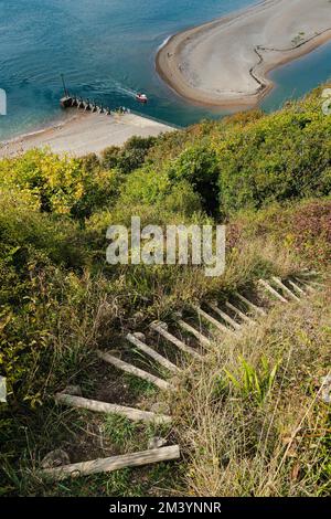 A vertical shot of a pathway on a grassy hilltop near the River Axe Estuary near Seaton, East Devon, UK Stock Photo