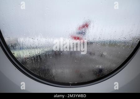 London, UK.  12 December 2022.  View through the window of an aircraft at Heathrow airport ahead of the Christmas getaway.  Runways are open after the Stock Photo