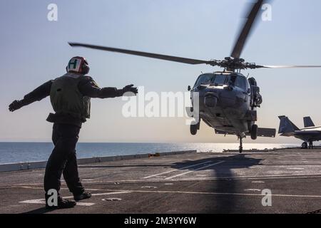 Aviation Electronics Technician Airman Robert Halo, from Charlotte, N.C., signals to an MH-60S Sea Hawk helicopter, assigned to Helicopter Sea Combat Squadron (HSC) 14, as it takes off from the flight deck of the Nimitz-class aircraft carrier USS Abraham Lincoln (CVN 72). Abraham Lincoln is currently underway conducting routine operations in U.S. 3rd Fleet. (U.S. Navy photo by Mass Communication Specialist 3rd Class Clayton Wren) Stock Photo