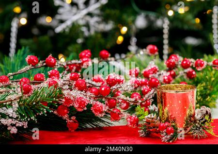 Red berries and a burning candle on Christmas background. Stock Photo