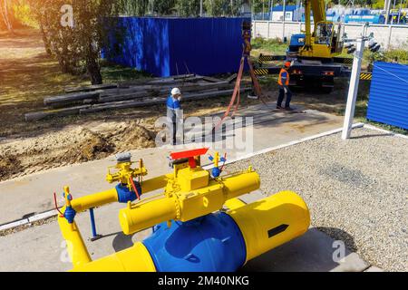 Two workers in construction helmets and overalls laying concrete slab on construction site on summer day. Contractors builders supervise laying of foundation on construction site. Authentic workflow. Stock Photo