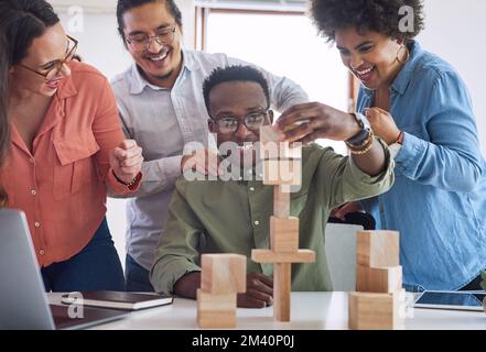 Future business growth is fostered with a solid foundation. a group of young businesspeople having a meeting with building blocks in a modern office. Stock Photo