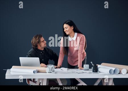Were always positive and creative when we work together. two young architects going over building plans and paperwork together in their office. Stock Photo